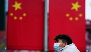 شاب صيني يرتدي كمامة ضمن إجراءات الحد من انتشار 