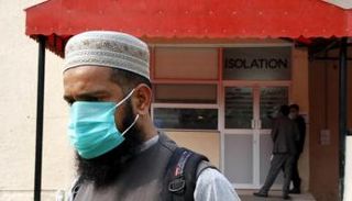 أحد الأشخاص يرتدي كمامة بسبب مخاوف فيروس كورونا - التايمز