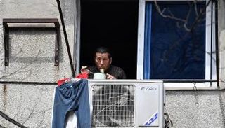 أحد سكان المدينة أثناء تناوله وجبة الغداء من شرفة منزله