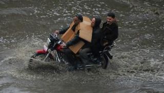 مواطنون يركبون دراجة نارية بأحد شوارع القاهرة