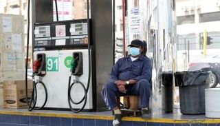 عامل يرتدي قناعا واقيا في محطة بنزين بالسعودية