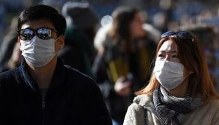 شاب وفتاة يتجولان مرتديين الكمامة للوقاية من كورونا
