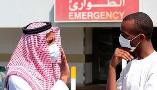 سعوديان يضعان الكمامة للوقاية من كورونا