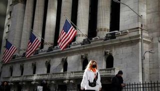 امرأة ترتدي قناعا بالقرب من بورصة نيويورك