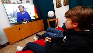 ألمان يتابعون كلمة لميركل عبر شاشات التلفزيون من المنازل