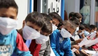 أطفال سوريون يرتدون كمامات بأحد مخيمات إدلب