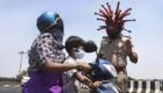 لحث المواطنين على عدم الخروج.. شرطي يرتدي "فيروس كورونا"