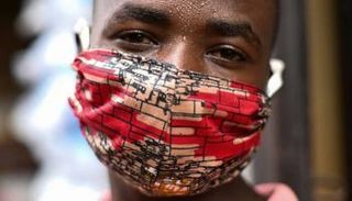 بائع في سوق برواندا يرتدي قناع قماش خشية كورونا