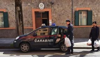 رجال الشرطة أثناء تقديمهم المواد الغذائية للأسرة