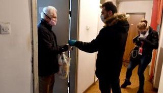 متطوع يسلم حصة غذائية لأحد المسنين في ساراييفو