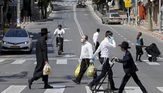 أشخاص يضعون كمامات خلال سيرهم في الشارع