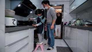 أب وابنته يحضران الطعام أثناء العزل المنزلي-أرشيفية