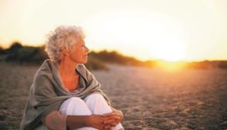 سيدة تجلس تحت أشعة الشمس للحصول على فيتامين 