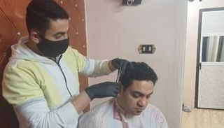 الحلاق المصري محمود بهجت يمارس عمله