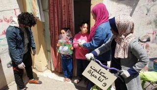 أعضاء المبادرة يوزعون الكتب على الأطفال