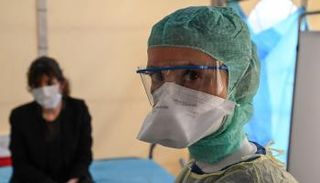 أحد أفراد الطاقم الطبي مع مصابة داخل مستشفى