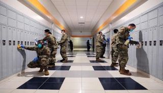 عناصر من الجيش الأمريكي يشاركون في أعمال التطهير- رويترز