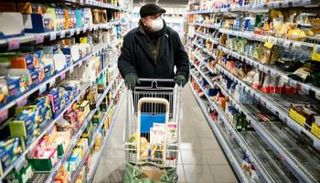 رجل يرتدي كمامة أثناء تسوقه داخل أحد المحال التجارية في برلين -د.ب.أ