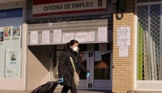 سيدة تسير بجوار أحد المحال التجارية المغلقة في إسبانيا