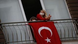 امرأة تطل من النافذة أثناء الحظر العام في تركيا
