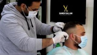 سامح سلام يمارس عمله بالكمامة والقفازات الطبية