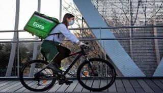 إحدى العاملات في أوبر إيتس تقود دراجة لتوصيل الطعام