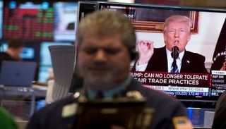 متعامل يتابع أداء البورصة الأمريكية أثناء خطاب لترامب