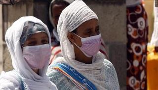 سيدتان ترتديان الكمامات في أحد شوارع الخرطوم
