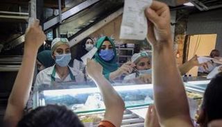 عمال يرتدون كمامات أثناء خدمة الزبائن في لبنان - تليجراف