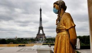 أحد التماثيل في العاصمة الفرنسية باريس يرتدي الكمامة