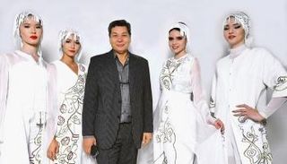 إيدارخان كالييف بجانب مجموعة من تصميماته
