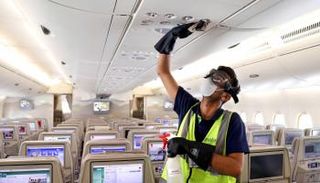 عامل يتولى تعقيم طائرة تابع لطيران الإمارات