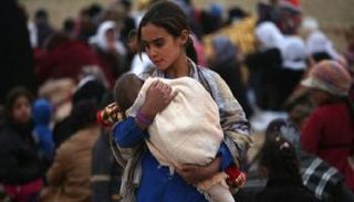 طفلة أيزيدية تحمل شقيقها الرضيع - أرشيفية