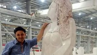 الدكتور أحمد عبدالكريم بجوار تمثال 