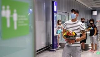 شاب يرتدي الكمامة خلال استقبال صديقته في المطار