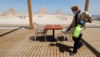 عامل يتولى تعقيم إحدى الاستراحات قرب أهرامات الجيزة