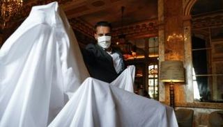 موظف يزيل الأغطية عن الأثاث في فندق كريون في باريس - أ ف ب