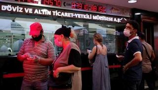 أتراك بمكتب صرافة في إسطنبول- رويترز