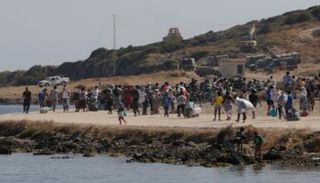 لاجئون من قرية موريا المدمرة يدخلون إلى مخيم مؤقت جديد