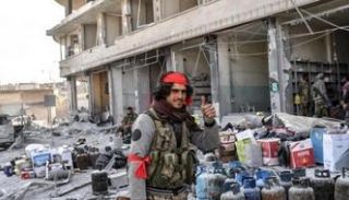 عنصر من مليشيات موالية لتركيا خلال سرقة متاجر في عفرين