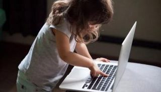 طفلة تستخدم جهاز لاب توب