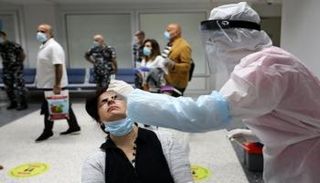 سيدة تخضع لاختبار كورونا في مطار بيروت الدولي