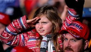 مواطن أمريكي يحمل طفلته خلال وقفة داعمة لترامب 