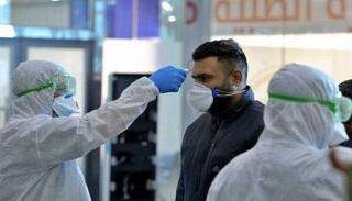 متخصص يطمئن على درجة حرارة أحد المواطنين بالجزائر