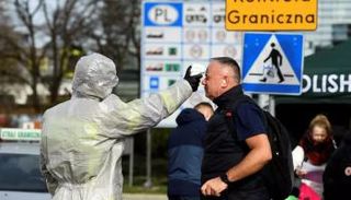 عامل صحي يقيس درجة حرارة رجل في ألمانيا