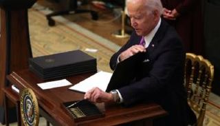 علبة أقلام أمام بايدن اثناء توقيعـه أوامر تنفيذية