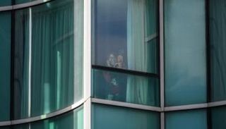 لي يونج سو خلف نافذة فندق الحجر الصحي في هونج كونج