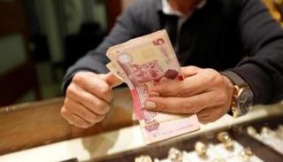 موظف يحصي أوراقا نقدية فئة 5 دنانير ليبية
