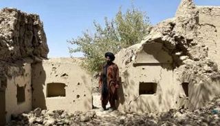مواطن أفغاني يتفقد أضرار منزله عقب غارة جوية