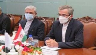 جانب من اجتماع المسؤول الإيراني وأمامه العلم المقلوب